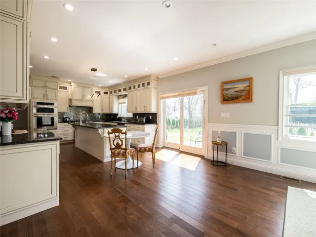 an open kitchen with white cabinets and stainless steel appliances