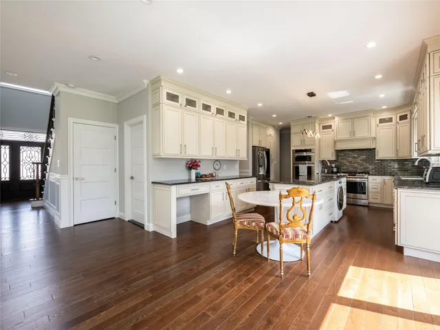 a kitchen with stainless steel appliances kitchen island wooden floors and white cabinets