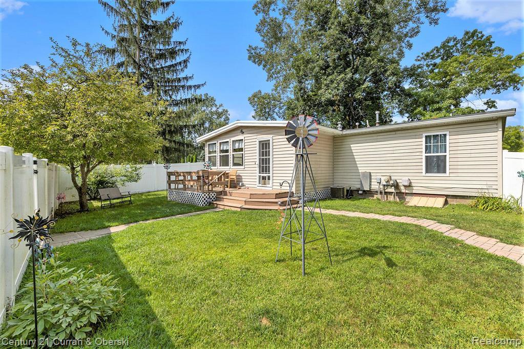 10228 Rexford Road Grass Lake, MI 49240 - Photo 16 of 24 Rear view of house with a fenced backyard and a wooden deck