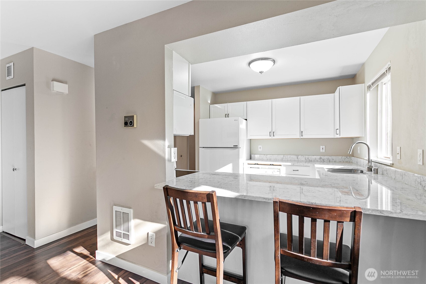 3350 Northwest Avenue, Unit 102 Bellingham, WA 98225 - Photo 13 of 28 a kitchen with a table chairs and a refrigerator