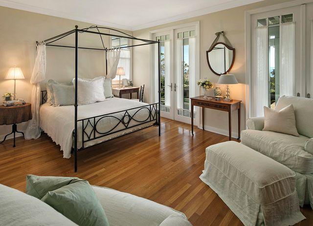 a bedroom with a bed a mirror and a window