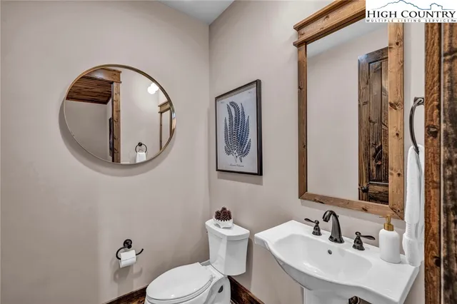 a bathroom with a toilet sink and mirror