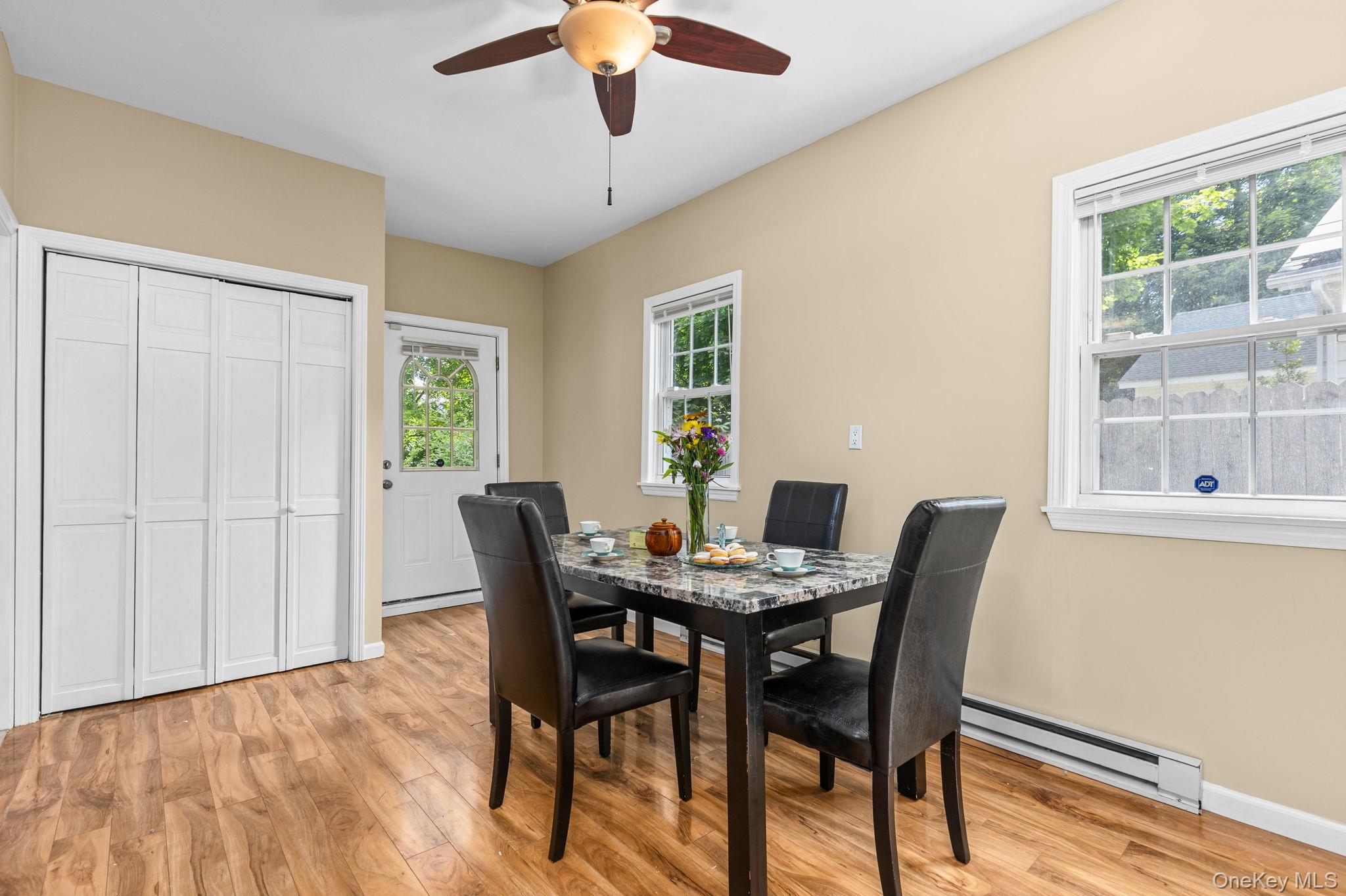 10 Batavia Road Patterson, NY 12563 - Photo 19 of 42 Dining area featuring wood-finish flooring, light beige wall paint, a white paneled bi-fold door, and multiple windows
