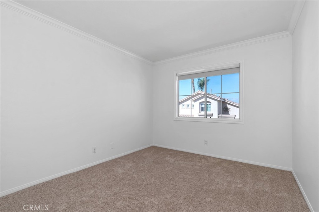 56 Acorn Ridge Rancho Santa Margarita, CA 92688 - Photo 33 of 57 Secondary Bedroom: Bright bedroom with soft carpeting, crown molding, and a window that provides natural light.