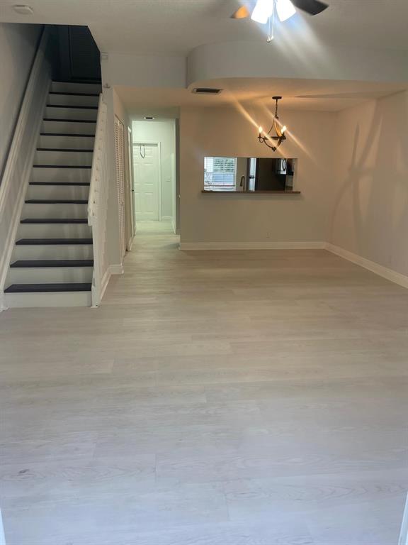 9967 Northwest 56th Place, Unit 9967 Coral Springs, FL 33076 - Photo 17 of 38 a view of a livingroom with wooden floor and stairs