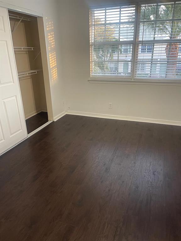 9967 Northwest 56th Place, Unit 9967 Coral Springs, FL 33076 - Photo 23 of 38 an empty room with wooden floor and windows