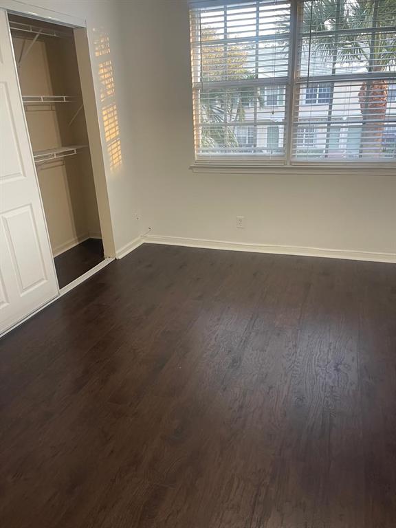 9967 Northwest 56th Place, Unit 9967 Coral Springs, FL 33076 - Photo 24 of 38 an empty room with wooden floor and windows