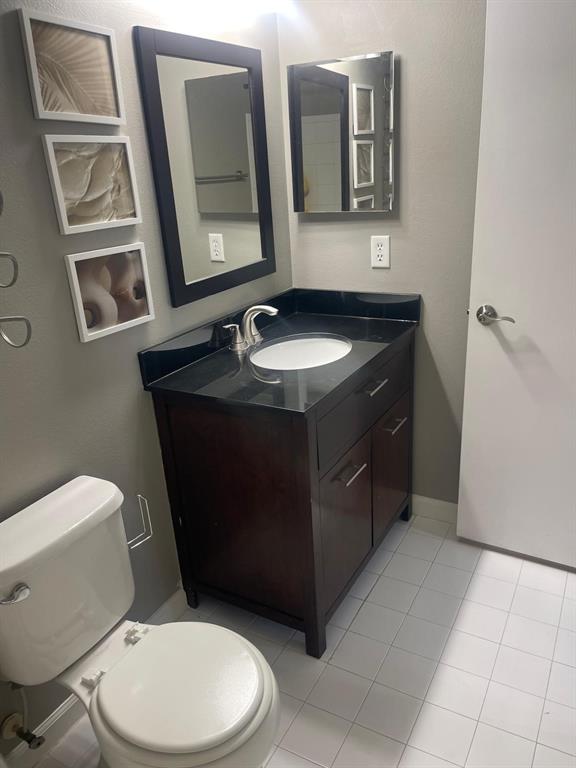9967 Northwest 56th Place, Unit 9967 Coral Springs, FL 33076 - Photo 25 of 38 a bathroom with a toilet sink and mirror