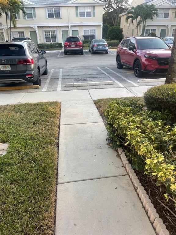 9967 Northwest 56th Place, Unit 9967 Coral Springs, FL 33076 - Photo 37 of 38 a couple of cars parked in front of a house