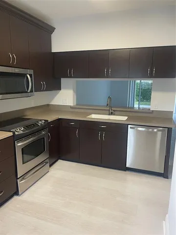 a view of a kitchen with a sink an oven and refrigerator