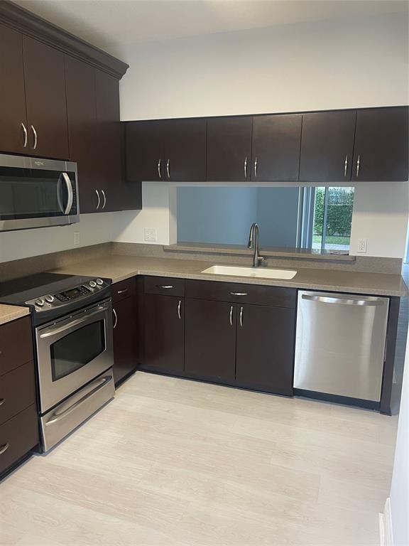 9967 Northwest 56th Place, Unit 9967 Coral Springs, FL 33076 - Photo 5 of 38 a kitchen with a sink and a stove