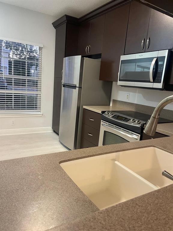 9967 Northwest 56th Place, Unit 9967 Coral Springs, FL 33076 - Photo 6 of 38 a view of a kitchen with a sink an oven and refrigerator