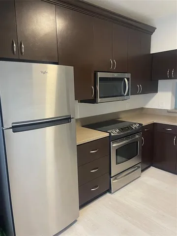 a large kitchen with a refrigerator and a sink