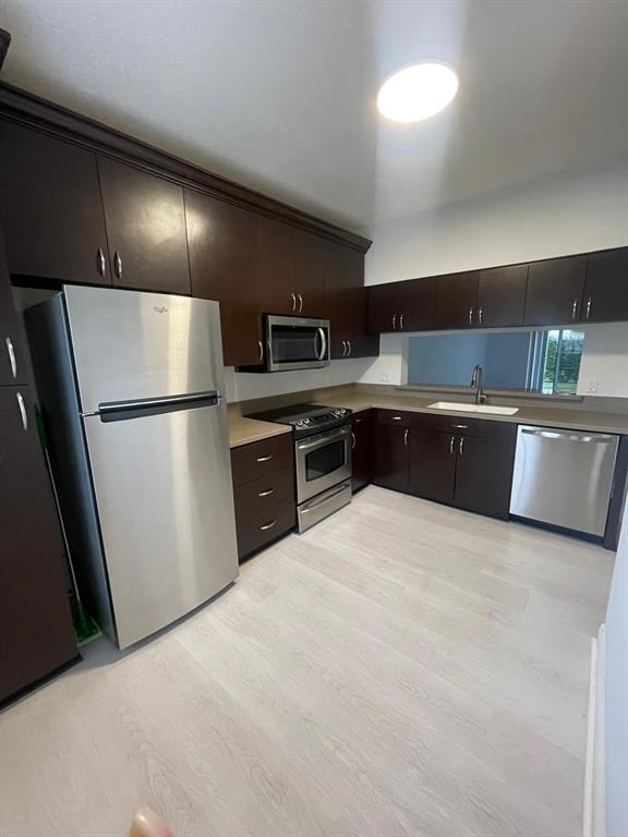 9967 Northwest 56th Place, Unit 9967 Coral Springs, FL 33076 - Photo 8 of 38 a large kitchen with a refrigerator and a sink