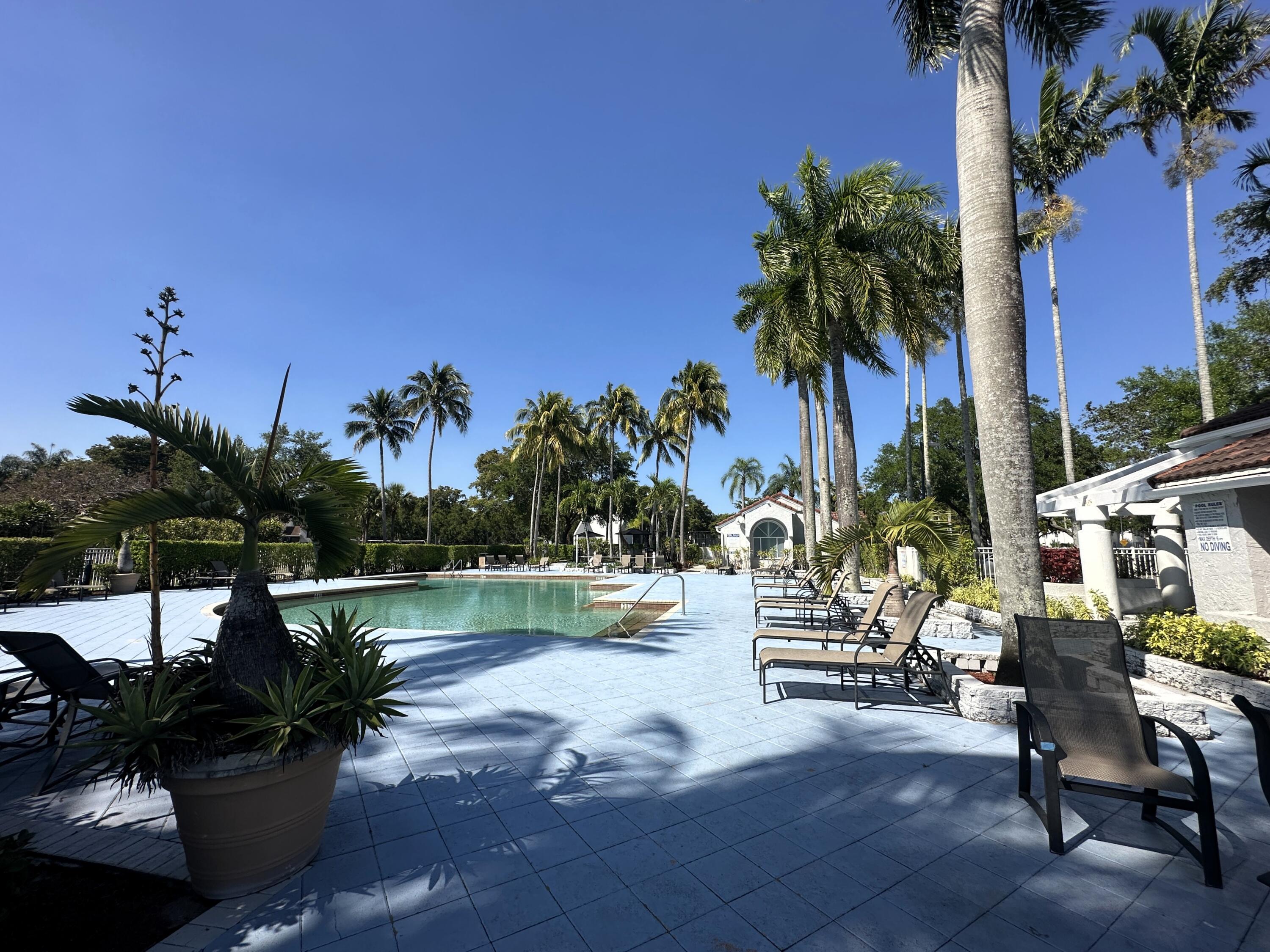 931 Lyons Road, Unit 4201 Coconut Creek, FL 33063 - Photo 25 of 47 a view of a lake with a table and chairs