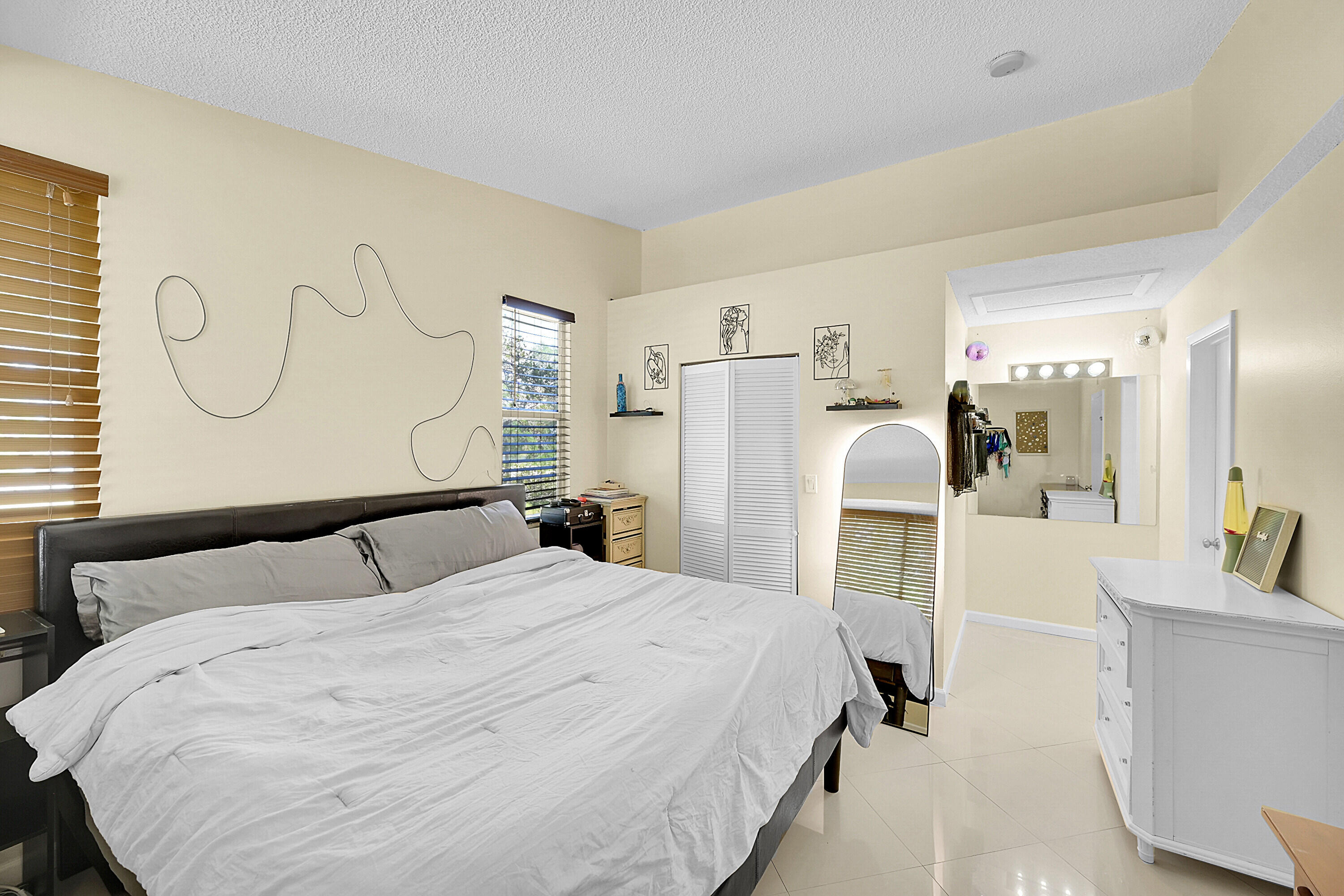 931 Lyons Road, Unit 4201 Coconut Creek, FL 33063 - Photo 10 of 47 a bedroom with a bed and a mirror