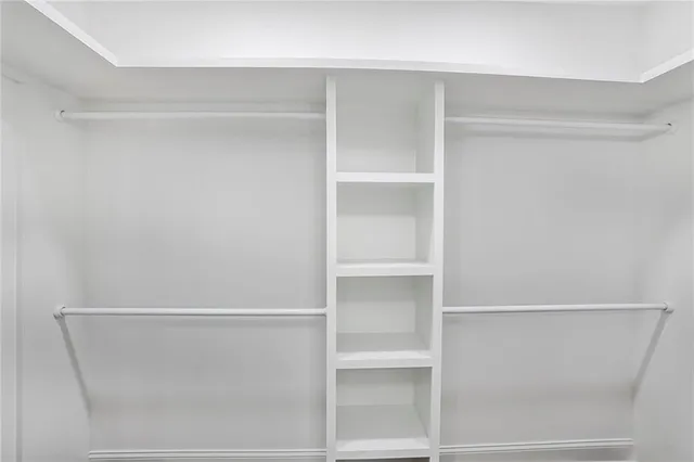 a view of walk in closet with empty racks
