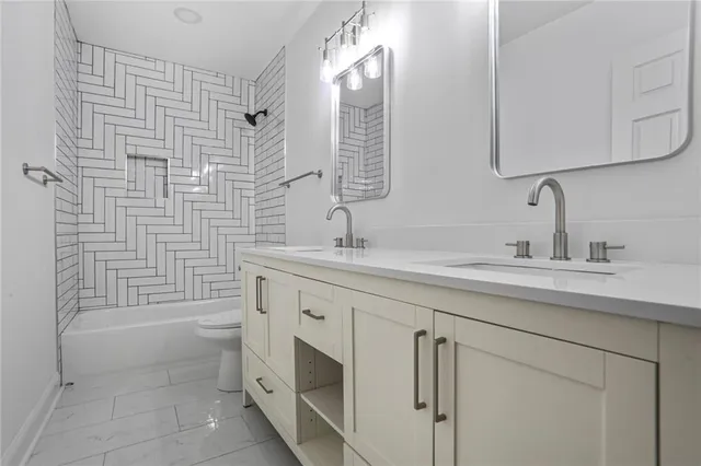 a bathroom with a double vanity sink a mirror and a bathtub