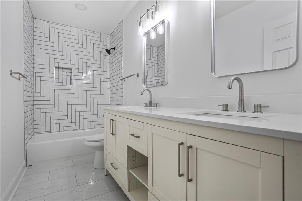 1321 Avon Avenue Southwest Atlanta, GA 30310 - Photo 16 of 20 a bathroom with a double vanity sink a mirror and a bathtub