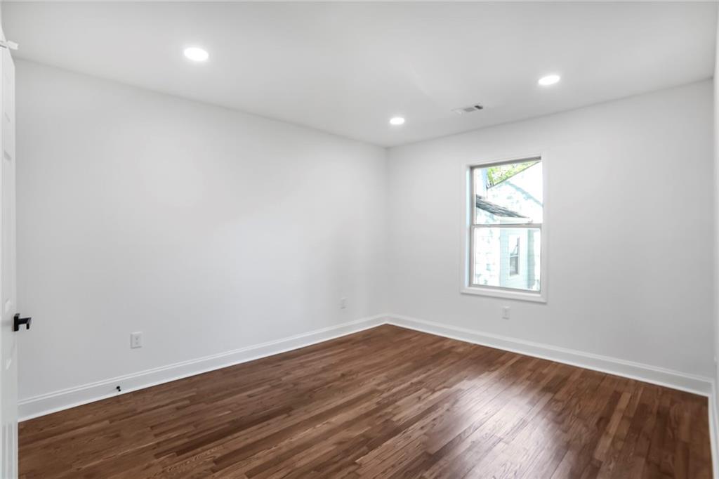 1321 Avon Avenue Southwest Atlanta, GA 30310 - Photo 17 of 20 an empty room with wooden floor and windows