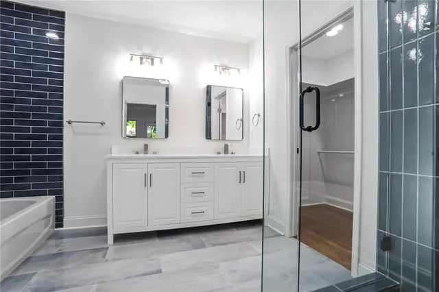 a bathroom with a double vanity sink a mirror and shower