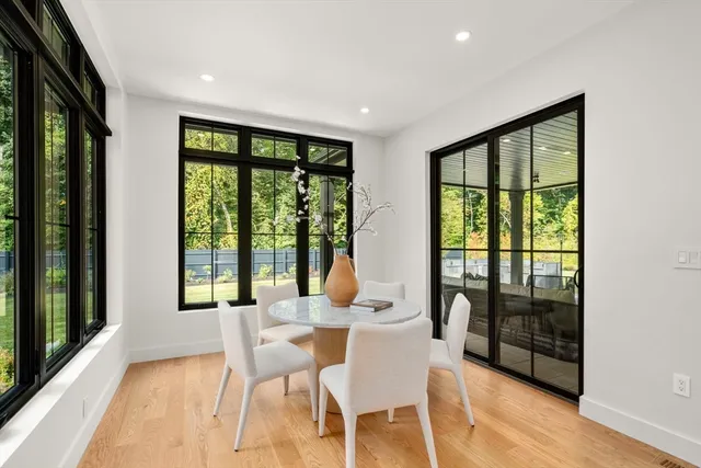 a dining room with furniture and large windows
