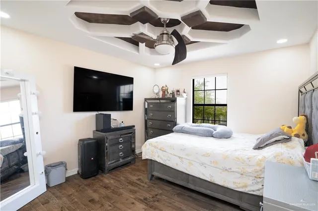 a bedroom with a bed and a flat tv screen on dresser