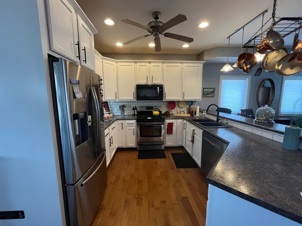 a kitchen with stainless steel appliances granite countertop a refrigerator a stove top oven a sink and dishwasher