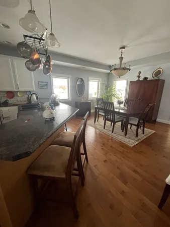 a view of a dining room with furniture a chandelier and wooden floor