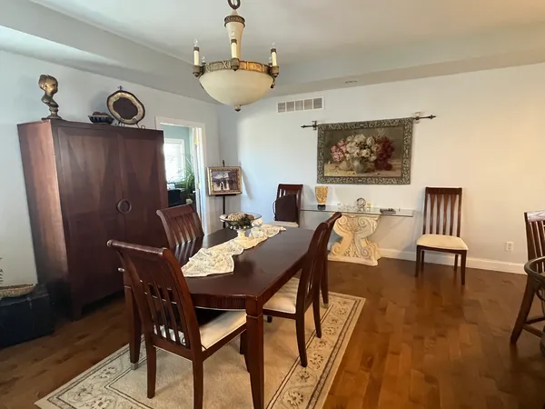 a view of a dining room with furniture wooden floor and a chandelier