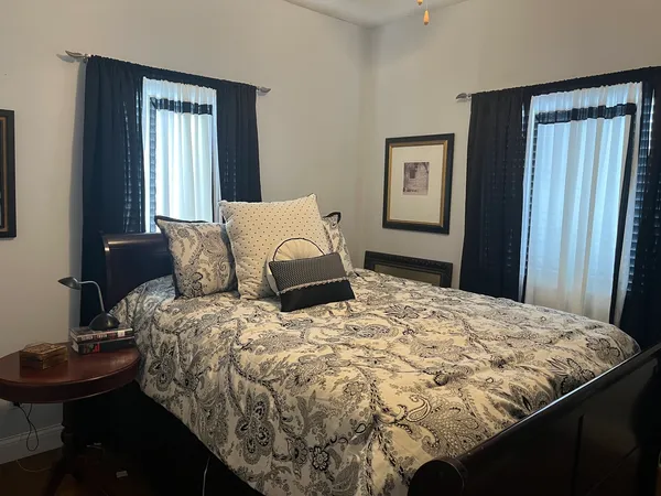 a bedroom with a bed and dresser with mirror