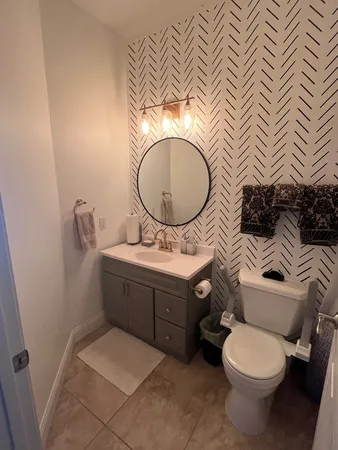 a bathroom with a granite countertop toilet and a sink