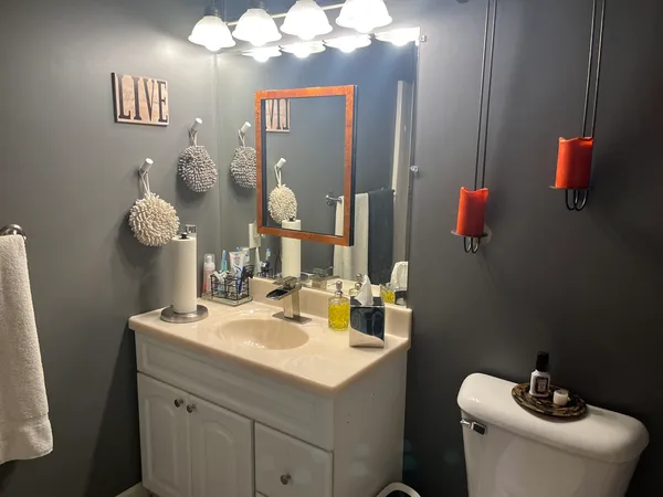 a bathroom with a toilet sink and mirror