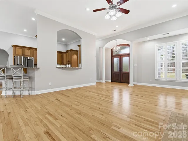 a view of an empty room with window and wooden floor