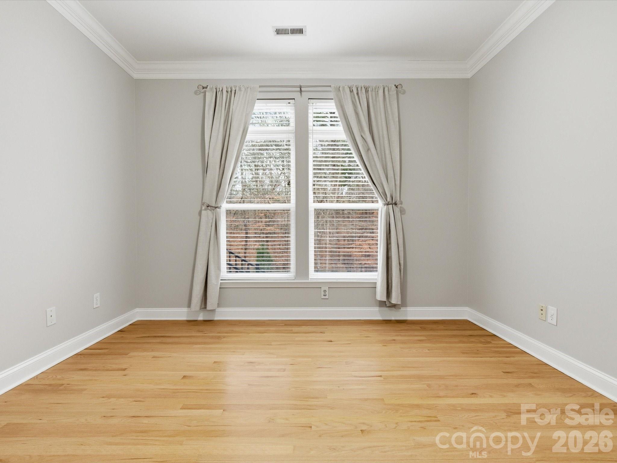 117 Abernathy Road Stanley, NC 28164 - Photo 44 of 47 an empty room with wooden floor and windows