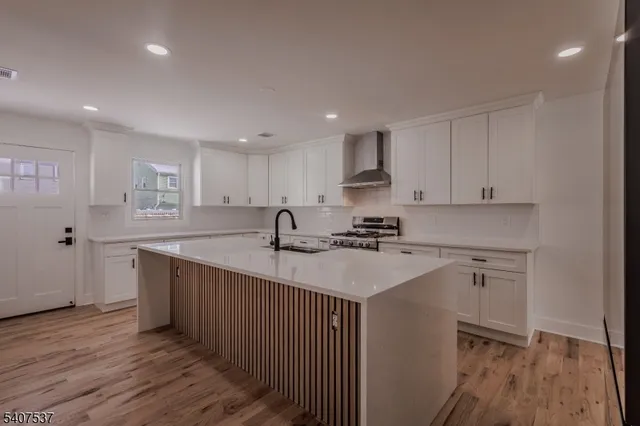 a kitchen with stainless steel appliances a sink a stove a refrigerator and cabinets