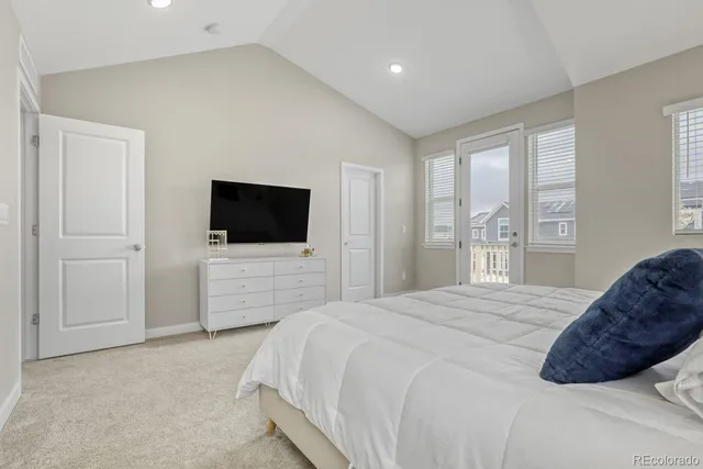 a bedroom with a bed a tv and wooden floor