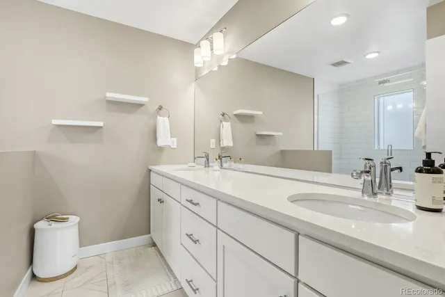 a bathroom with a double vanity sink mirror and toilet