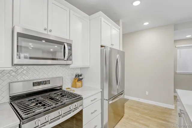 a kitchen with stainless steel appliances granite countertop a refrigerator and a stove top oven