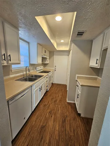 a kitchen with a sink and wooden floor