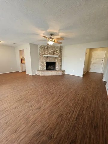 a view of empty room with fireplace and wooden floor