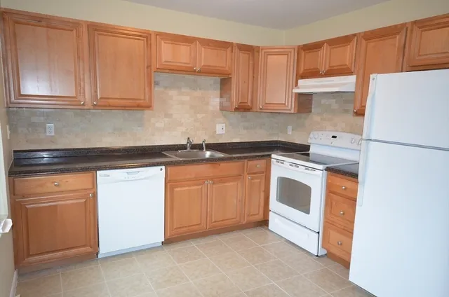 a kitchen with stainless steel appliances granite countertop white refrigerator stove a sink and dishwasher