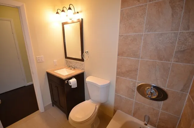 a bathroom with a toilet a sink and mirror