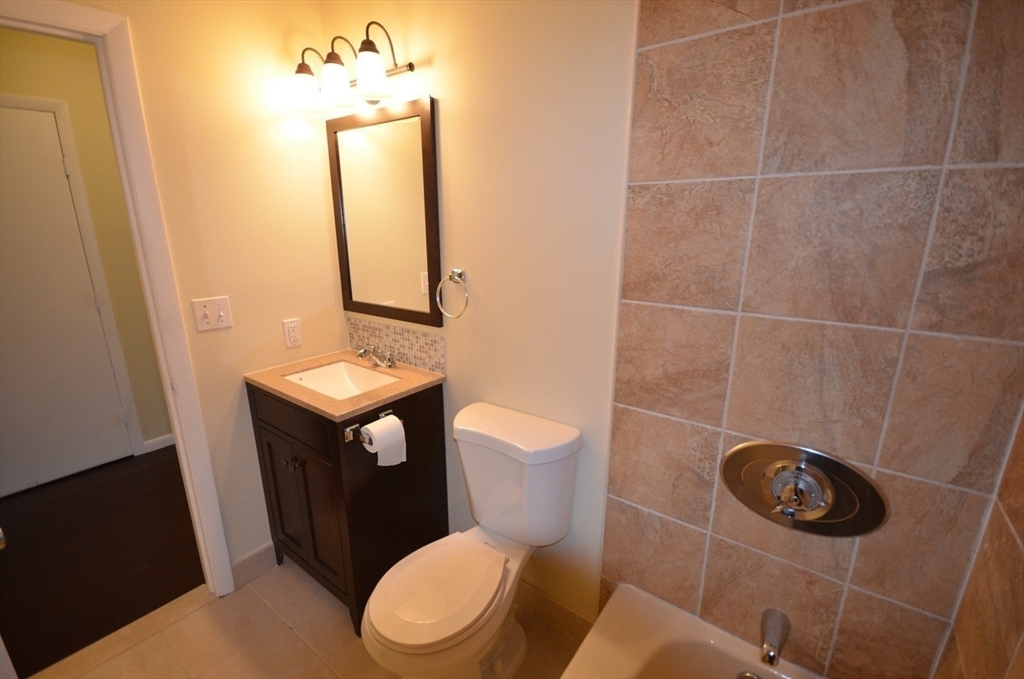 128 Marginal Street, Unit 2 Boston, MA 02128 - Photo 5 of 10 a bathroom with a toilet a sink and mirror