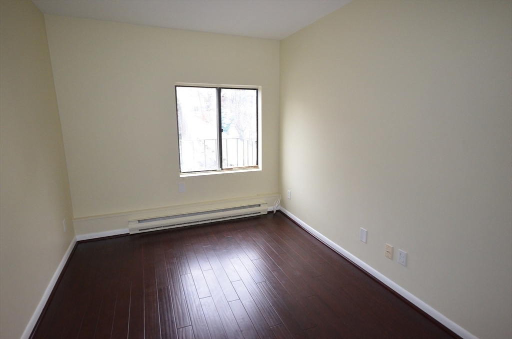 128 Marginal Street, Unit 2 Boston, MA 02128 - Photo 8 of 10 an empty room with wooden floor and windows