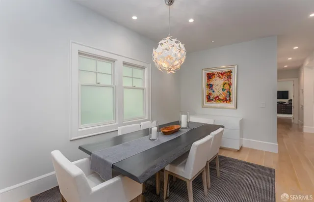 a view of a dining room with furniture a chandelier and wooden floor