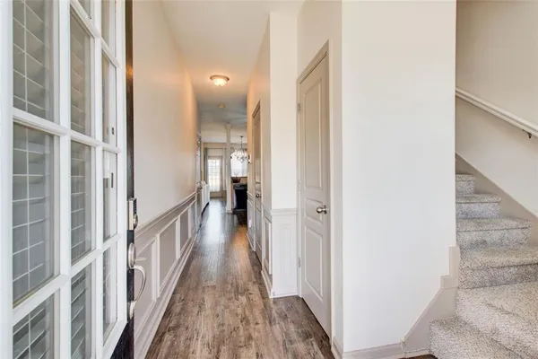 a view of a hallway with wooden floor and staircase