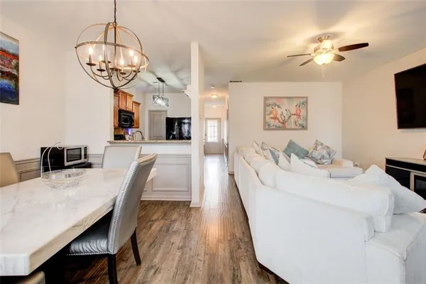 a living room with furniture a chandelier a flat screen tv and a chandelier