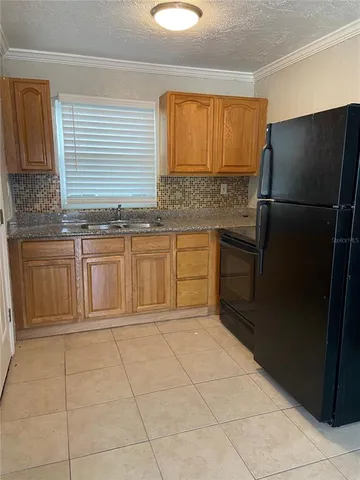 a kitchen with stainless steel appliances granite countertop a refrigerator and a sink