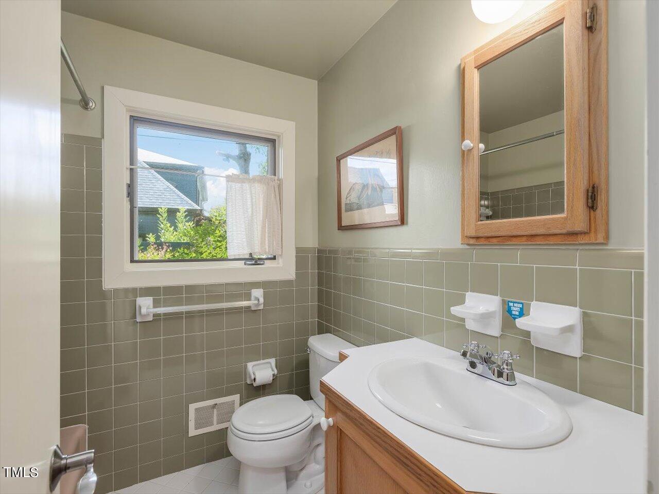 2129 Ridge Road Raleigh, NC 27607 - Photo 57 of 79 a bathroom with a sink mirror and toilet